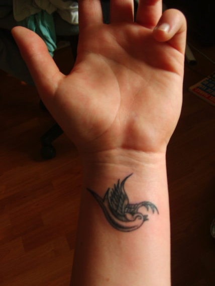 man's wrist. Small tattoos