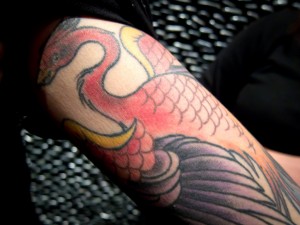Red phoenix tattoo on arm