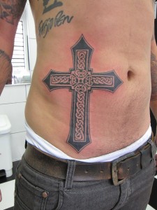 Cross tattoo on man's stomach