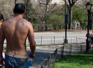 Simple cross tattoo on man's shoulder