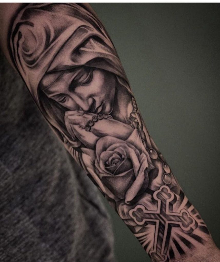 Black and grey Virgin Mary tattoo on the upper arm