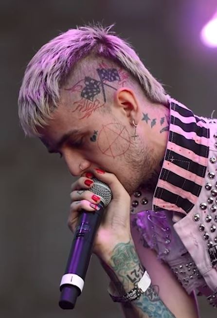 White rapper with face tattoos and pink hair