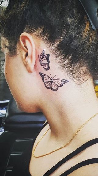 Fine line butterfly tattoo on the neck