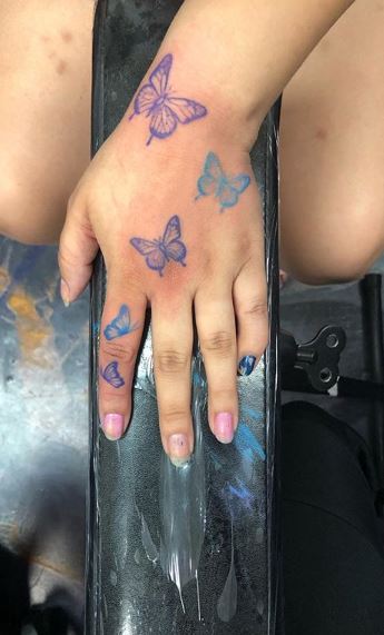Blue purple Butterfly going up hand tattoo