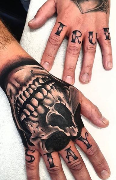 Black and grey skull wrist wrapper tattoo