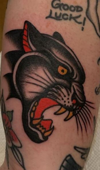 Tattoo of a cross between a realistic black panther...