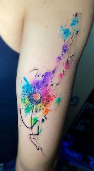 Watercolor style tattoo of a dandelion flower on the