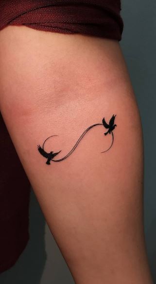 Wrist tattoo of a infinity symbol with three birds on
