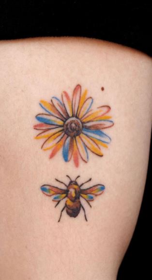 Watercolor flower and bee tattoo on the upper back