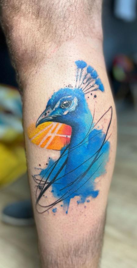 Freehand peacock tattoo on the left arm.